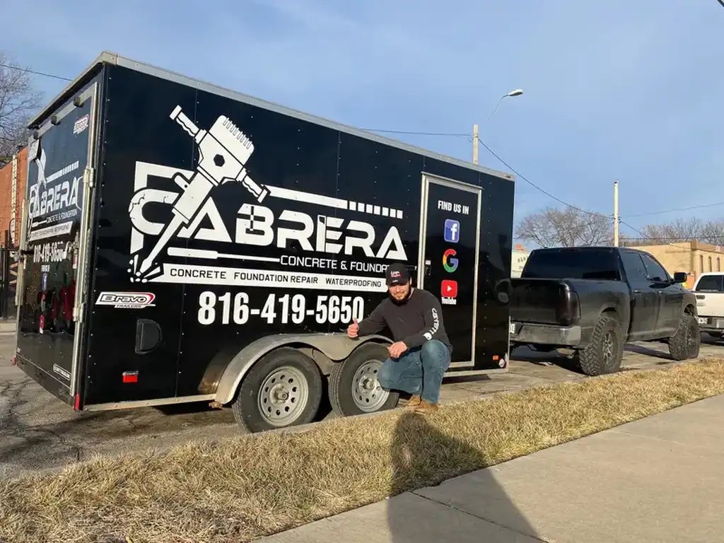 Cabrera Concrete trailer with the business name and phone number beside a work truck in Kansas City.